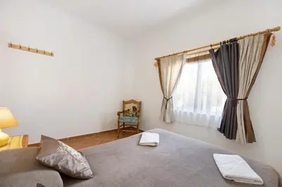 a bedroom with a bed with two towels on it at Casa Do Poço in Budens