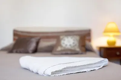 a bed with two white towels on top of it at Casa Do Poço in Budens