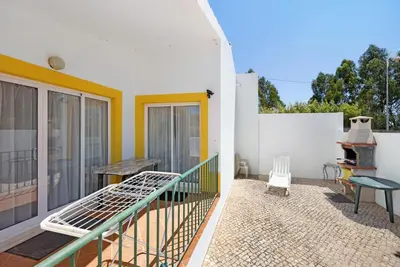 a balcony of a house with a bed and a table at Casa Do Poço in Budens
