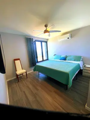 a bedroom with a green bed and a chair at Ocean Front in Paul do Mar