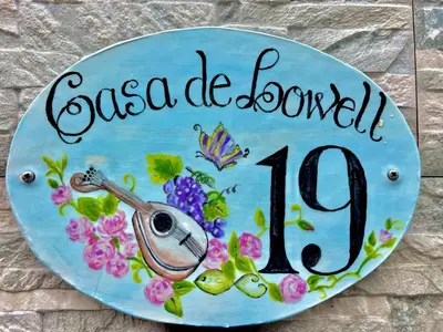 a sign with a violin and flowers on it at Ocean Front in Paul do Mar