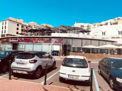 a group of cars parked in a parking lot with a train at Seaview Apartment walking to the Beach in Funchal