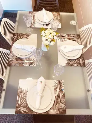 a table with white plates and napkins on it at Seaview Apartment walking to the Beach in Funchal