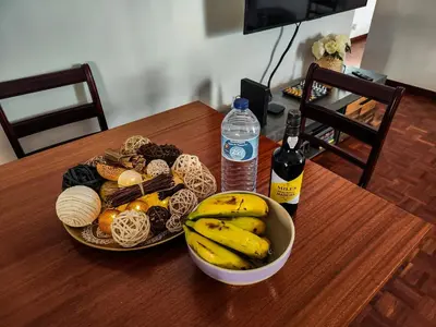 a table with a bowl of bananas and a bottle of water at Casa Ascenção, vista mar Madeira in Funchal