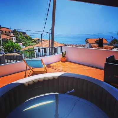 a hot tub on a balcony with a view of the ocean at Casa Ascenção, vista mar Madeira in Funchal