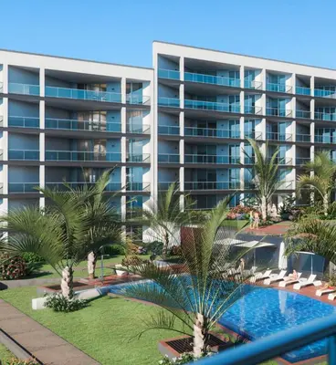 an apartment building with a swimming pool and palm trees at Madeira Residence Apartments T2 in Funchal