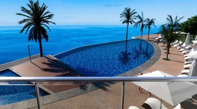 a swimming pool with the ocean in the background at Madeira Residence Apartments T2 in Funchal