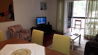 a living room with a table and chairs and a television at Apartamento Capela in Funchal