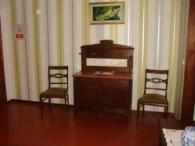 a room with two chairs and a wooden cabinet at Apartamento Capela in Funchal