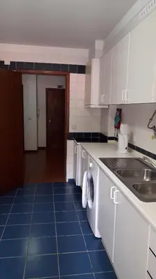 a kitchen with white cabinets and a blue tile floor at Apartamento Capela in Funchal