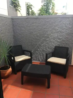 two chairs and a table in front of a wall at Apartamento Capela in Funchal