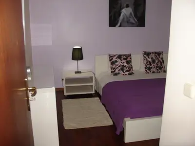 a bedroom with a bed and a lamp on a night stand at Apartamento Capela in Funchal
