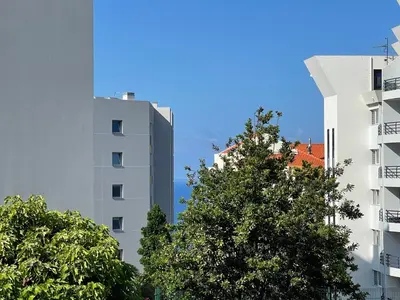 two tall buildings with trees in front of them at Beach&Comfort Cozy Apartment by the Ocean in Funchal