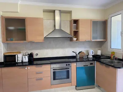 a kitchen with wooden cabinets and a blue oven at Beach&Comfort Cozy Apartment by the Ocean in Funchal