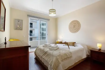 a bedroom with a bed and a desk and a window at Apartamento Fénix Garajau in Caniço