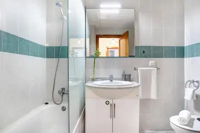 a bathroom with a sink and a shower and a toilet at Apartamento Fénix Garajau in Caniço