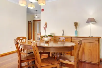 a dining room with a wooden table and chairs at Apartamento Fénix Garajau in Caniço