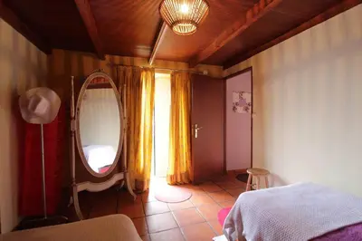a bedroom with a large mirror and a bed at Cozy and traditional stone house in Arco da Calheta