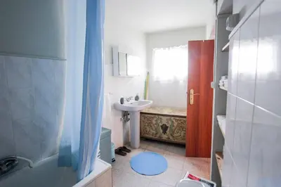 a small bathroom with a sink and a shower at Cozy and traditional stone house in Arco da Calheta