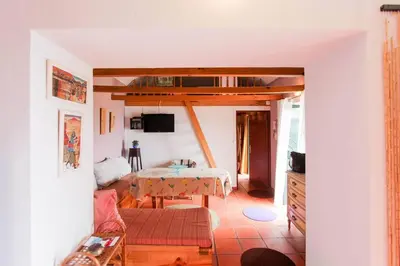 a living room with a table and a couch at Cozy and traditional stone house in Arco da Calheta