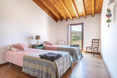 a room with two beds and a window and a chair at Casa Mira Vale - Calm Country House by Lisbeyond in Aljezur