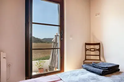 a bedroom with a window and a bed and a chair at Casa Mira Vale - Calm Country House by Lisbeyond in Aljezur