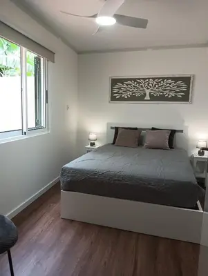 a bedroom with a bed and two windows at Maresia's House in Madalena do Mar