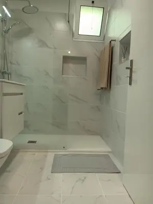 a white bathroom with a shower and a toilet at Maresia's House in Madalena do Mar