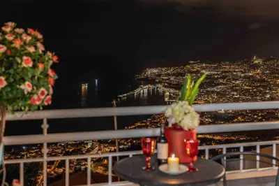 a view of a city from a balcony at night at Villa das Furnas in Funchal