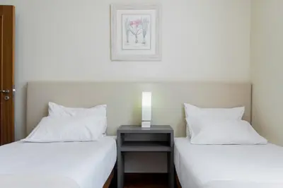 two beds in a room with a nightstand between them at Achada I by An Island Apart in Funchal