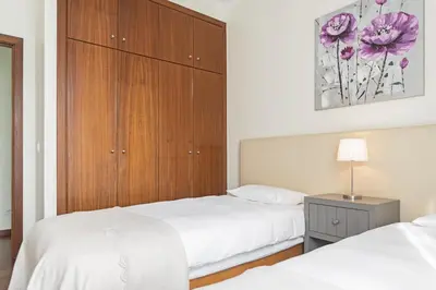 a bedroom with two beds and a wooden cabinet at Achada I by An Island Apart in Funchal