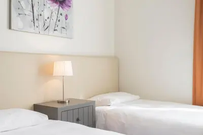a bedroom with two beds and a table with a lamp at Achada I by An Island Apart in Funchal