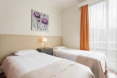 two beds in a hotel room with a window at Achada I by An Island Apart in Funchal