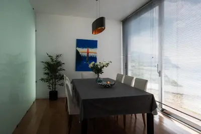 a dining room with a table and chairs and a window at Sea View Villa Mar Lindo nr Ponta do Sol in Ponta do Sol
