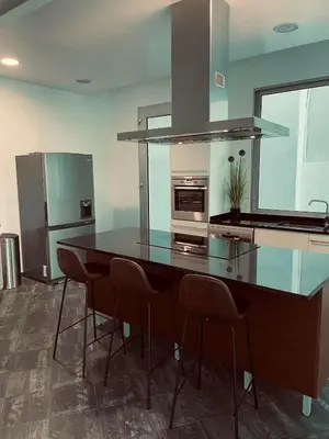 a kitchen with a counter with chairs and a counter top at Sea View Villa Mar Lindo nr Ponta do Sol in Ponta do Sol