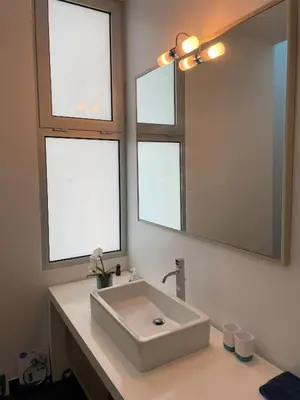 a bathroom with a white sink and two windows at Sea View Villa Mar Lindo nr Ponta do Sol in Ponta do Sol