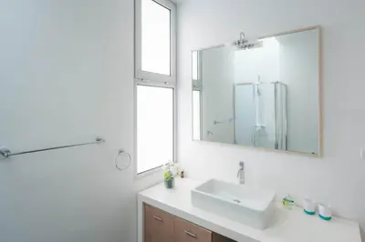 a white bathroom with a sink and a mirror at Sea View Villa Mar Lindo nr Ponta do Sol in Ponta do Sol