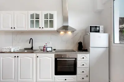 a white kitchen with a sink and a refrigerator at Babosas Charm in Funchal