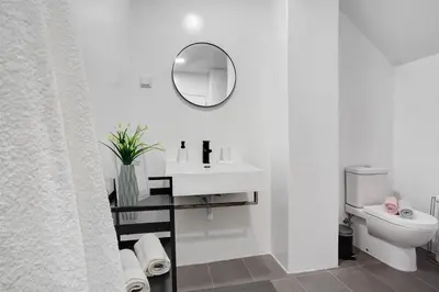a white bathroom with a sink and a toilet at Babosas Charm in Funchal