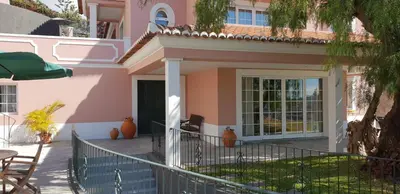 a pink house with a porch and a patio at Casa da Quinta in Funchal