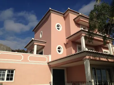 a pink house with a balcony on top of it at Casa da Quinta in Funchal