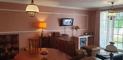 a living room with a table and a tv on a wall at Casa da Quinta in Funchal