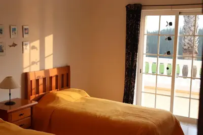 a bedroom with two beds and a window at Stunning Villa with Pool & View near beach in Budens