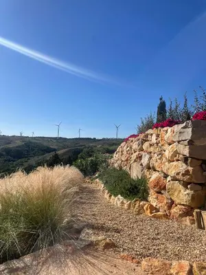 a stone wall next to a dirt road at Stunning Villa with Pool & View near beach in Budens