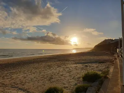 a view of a beach with the sun setting at Stunning Villa with Pool & View near beach in Budens