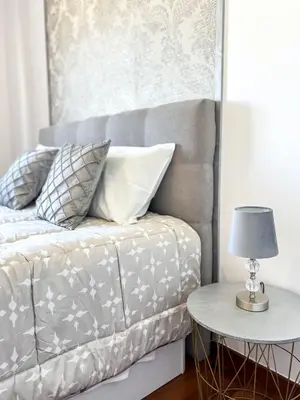 a bed with pillows and a table with a lamp at The Pink Villa - Holidays in Madeira Island in Caniço