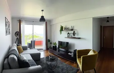 a living room with a couch and a tv at The Pink Villa - Holidays in Madeira Island in Caniço