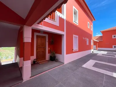 a red and white building with a door at The Pink Villa - Holidays in Madeira Island in Caniço