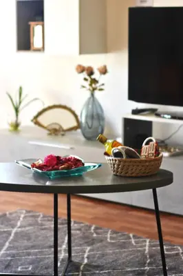 a basket with a bottle of alcohol and a bowl of fruit at Ocean Hill House by Rentery Madeira in Santa Cruz