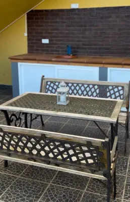 a patio with yellow columns and a table on the floor at Ocean Hill House by Rentery Madeira in Santa Cruz